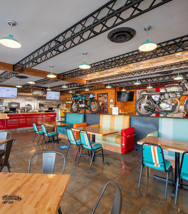 alt=" The interior of the smokey and the brisket restaurant featuring some motorbikes and tables"